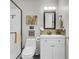 Clean bathroom featuring white fixtures, a glass-enclosed shower, and quirky art, creating a welcoming space at 208 Sumter Ave, Summerville, SC 29483