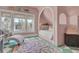 Bright, pink bedroom offers a built-in bed nook, sitting chair, and large windows with natural light at 208 Sumter Ave, Summerville, SC 29483