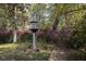 Unique birdhouse surrounded by lush greenery and blooming azaleas in a serene garden at 208 Sumter Ave, Summerville, SC 29483