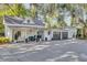 Charming white cottage with a black metal roof, inviting front porch, and a three-car garage at 208 Sumter Ave, Summerville, SC 29483
