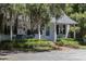 Quaint cottage exterior with a cozy porch and lush, mature landscaping at 208 Sumter Ave, Summerville, SC 29483