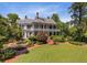 Grand home with a spacious lawn, beautifully landscaped gardens, and mature trees create a serene setting at 208 Sumter Ave, Summerville, SC 29483