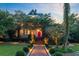 Charming home with a vibrant red door, complemented by lush landscaping and a welcoming brick pathway at 208 Sumter Ave, Summerville, SC 29483