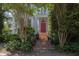 Elegant brick steps lead to a red door, framed by columns and lush greenery, with a charming sidelight window at 208 Sumter Ave, Summerville, SC 29483