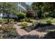 Beautifully landscaped front yard with brick pathways, manicured garden beds, and mature trees at 208 Sumter Ave, Summerville, SC 29483