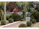 Gated entrance with lanterns surrounded by lush greenery and flowering trees, enhancing curb appeal and privacy at 208 Sumter Ave, Summerville, SC 29483