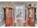 Beautiful hallway with dark floors, floral wallpaper and arched curio cabinets at 208 Sumter Ave, Summerville, SC 29483