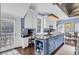 Bright kitchen features a large blue island, white cabinetry, granite countertops, and stainless steel appliances at 208 Sumter Ave, Summerville, SC 29483
