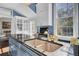View of a blue island with a granite countertop with a sink, a chandelier, and custom white cabinetry at 208 Sumter Ave, Summerville, SC 29483