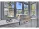 This sunlit kitchen boasts built-in stainless steel grill and cooktop with views of the outdoor space at 208 Sumter Ave, Summerville, SC 29483