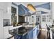 Bright kitchen features a blue island with a sink, a statement chandelier, and stainless steel appliances at 208 Sumter Ave, Summerville, SC 29483