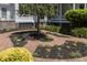 Beautiful landscaping featuring brick pathways, mature trees, and lush plantings create a tranquil outdoor space at 208 Sumter Ave, Summerville, SC 29483