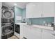 Efficient laundry room featuring a stacked washer and dryer, ample counter space, and modern white cabinets at 208 Sumter Ave, Summerville, SC 29483