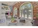 Inviting living room boasting brick wall, open staircase, pool view through windows, and stylish decor at 208 Sumter Ave, Summerville, SC 29483