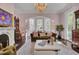 Bright living room with large windows, a marble fireplace, a crystal chandelier, and classic furniture at 208 Sumter Ave, Summerville, SC 29483