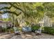 Inviting patio with comfortable seating area under a large, shady tree covered in Spanish moss at 208 Sumter Ave, Summerville, SC 29483