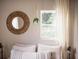 Bedroom close-up featuring a cozy bed with decorative pillows, a window, and a round mirror at 2157 Jeff St, North Charleston, SC 29405