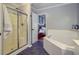 Bright bathroom with a tiled shower and a soaking tub adjacent to an open bedroom door at 2228 Daniel Island Dr, Charleston, SC 29492