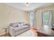 Cozy bedroom featuring hardwood floors, two windows, a comfortable sofa, and a work desk at 2228 Daniel Island Dr, Charleston, SC 29492