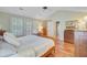 Vaulted Primary bedroom with wood floors, ceiling fan, shuttered windows, and plenty of dresser storage at 2228 Daniel Island Dr, Charleston, SC 29492