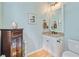 Bathroom with a granite countertop, white cabinets, framed mirror, and hardwood flooring at 2228 Daniel Island Dr, Charleston, SC 29492