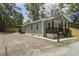 Attractive home featuring a quaint front porch, gravel driveway, and a newly constructed fence at 227 Grace St, Walterboro, SC 29488