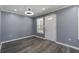 Living room with gray walls, vinyl flooring, modern ceiling fan and a door to the porch at 227 Grace St, Walterboro, SC 29488