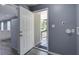 This mudroom shows an open back door, gray walls, and a view to the kitchen at 227 Grace St, Walterboro, SC 29488