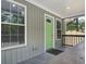View of a charming porch featuring gray tiling, a bright green door, and lots of natural light at 227 Grace St, Walterboro, SC 29488