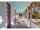 Spacious front porch with seating offering beautiful views of the property's lush landscaping at 2514 Myrtle Ave, Sullivans Island, SC 29482