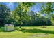 Large grassy backyard with storage shed and mature trees in a serene setting at 286 Mallard Lake Rd, Dorchester, SC 29437