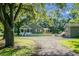 Exterior shot capturing home and detached building with a charming picket fence, surrounded by mature trees and a gravel driveway at 286 Mallard Lake Rd, Dorchester, SC 29437