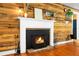 Cozy fireplace with brick hearth and white mantel surrounded by wood paneling to add warmth to this living space at 286 Mallard Lake Rd, Dorchester, SC 29437