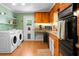 Efficient kitchen and laundry room with wooden cabinets, modern appliances, and a back door leading outside at 286 Mallard Lake Rd, Dorchester, SC 29437