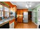 Practical kitchen area featuring wooden cabinets, appliances, and plenty of natural light from the window over the sink at 286 Mallard Lake Rd, Dorchester, SC 29437