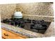 A close-up of a modern flat top electric stove with stone countertops and wooden cabinets in the background at 286 Mallard Lake Rd, Dorchester, SC 29437