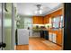 Functional kitchen with wooden cabinets, laminate countertops, a convenient laundry area, and linoleum flooring at 286 Mallard Lake Rd, Dorchester, SC 29437