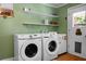 A laundry area with shelving and modern washer and dryer units, with a door that leads outside at 286 Mallard Lake Rd, Dorchester, SC 29437