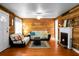 Warm and inviting living room features wood paneled walls, hardwood floors and a cozy fireplace at 286 Mallard Lake Rd, Dorchester, SC 29437