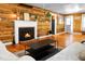 Bright living room featuring wood-paneled walls, a fireplace with a white mantle, and hardwood floors at 286 Mallard Lake Rd, Dorchester, SC 29437