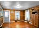 A well-lit living room featuring wood-paneled walls, hardwood flooring, and natural light from two large windows at 286 Mallard Lake Rd, Dorchester, SC 29437