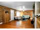 Cozy living room with hardwood floors, wood-paneled walls, comfortable seating, and a doorway to another room at 286 Mallard Lake Rd, Dorchester, SC 29437