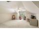 Finished attic space with neutral carpet, a ceiling fan, and plenty of natural light from the arched window at 2938 Old Drake Dr, Seabrook Island, SC 29455