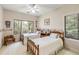 Cozy bedroom with twin beds, ceiling fan, and natural light streaming in from large windows with wooded view at 2938 Old Drake Dr, Seabrook Island, SC 29455