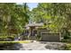 Inviting front exterior featuring a well-manicured lawn, mature trees, and a welcoming entrance with a two car garage at 2938 Old Drake Dr, Seabrook Island, SC 29455
