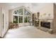 Bright living room with large windows, stone fireplace, and built-in bookshelves at 2938 Old Drake Dr, Seabrook Island, SC 29455