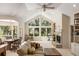 An inviting living area with a stone fireplace, high ceilings, large windows, and a view of the lush backyard at 2938 Old Drake Dr, Seabrook Island, SC 29455