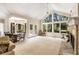 Bright, expansive living room with a cozy fireplace, large windows offering serene views, and elegant French doors at 2938 Old Drake Dr, Seabrook Island, SC 29455