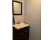 A bathroom features a dark vanity, neutral countertops, a framed mirror, and neutral paint at 306 Park St, Saint George, SC 29477