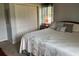 This bedroom features a window, a white quilt with green leaf design, decorative pillows, and a closet for plenty of storage at 306 Park St, Saint George, SC 29477
